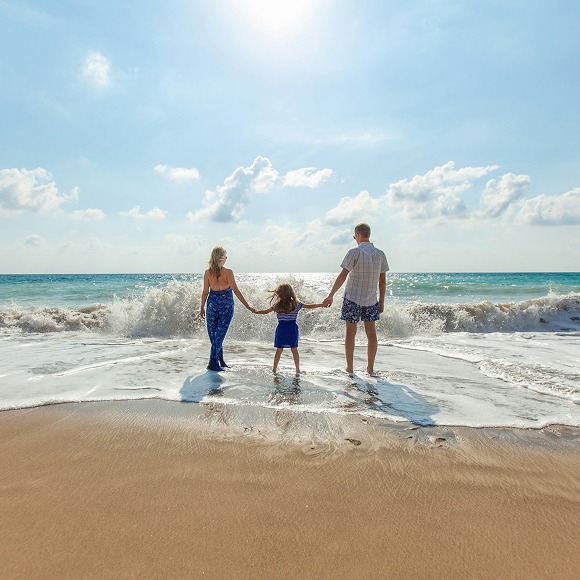 Familia paseando por la orilla del mar en la Costa Dorada